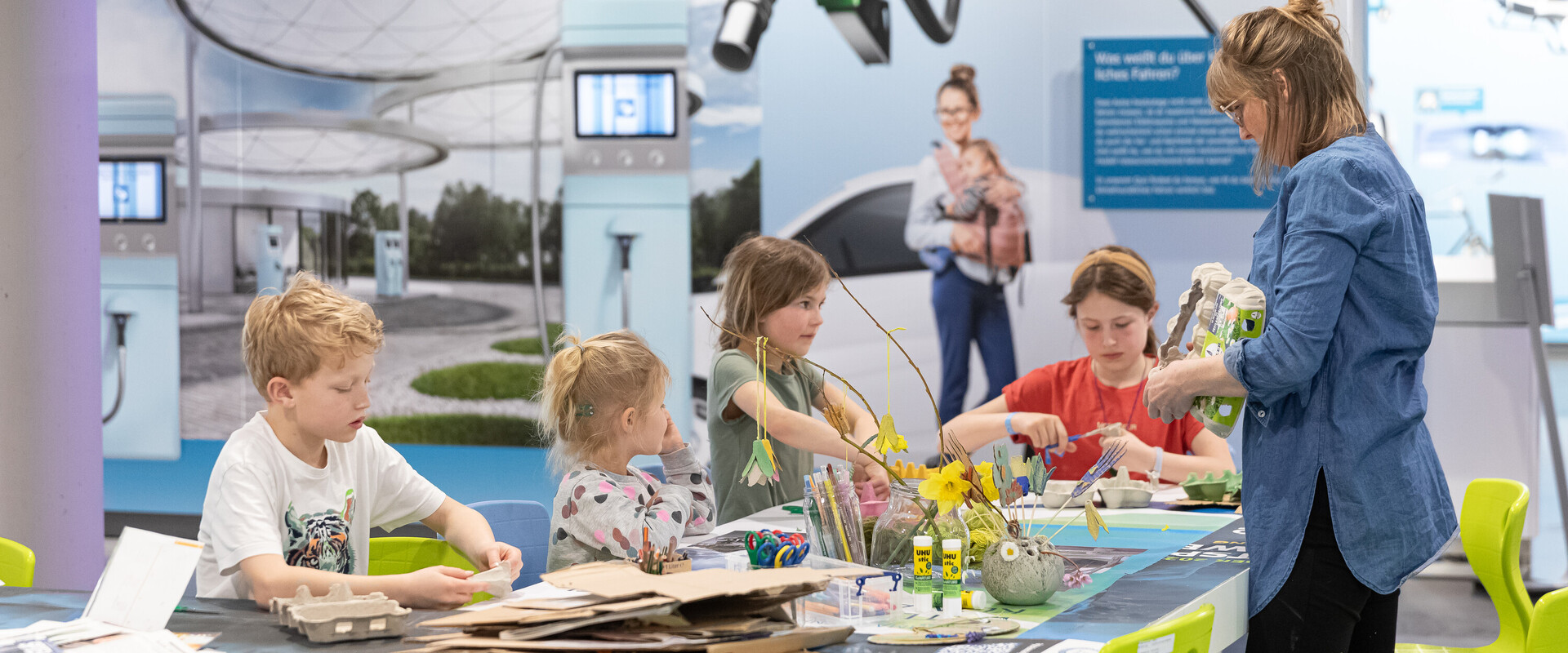 Kinder am Basteltisch in der Ausstellung der KLIMAARENA.