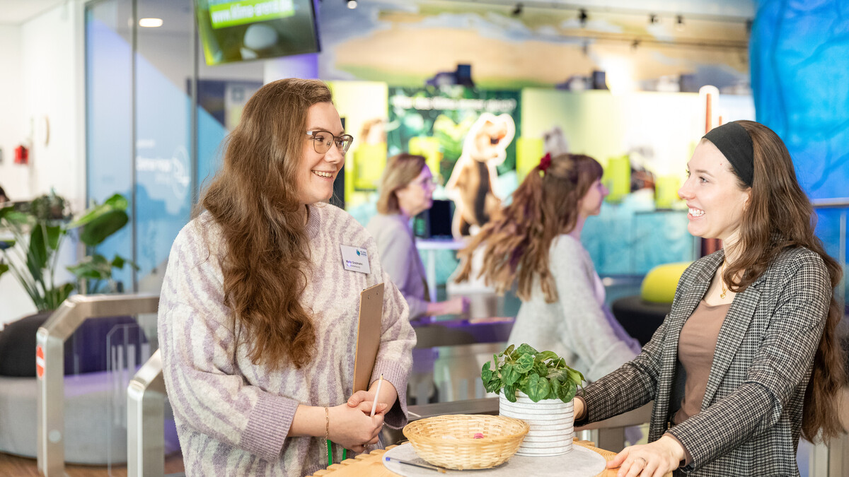 Teamfoto von zwei Mitarbeiterinnen der Klima Arena, die sich am Empfang unterhalten